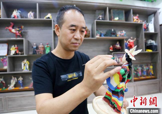 圖為安秋平正在創(chuàng)作代表隴南文縣民俗的《白馬人》作品。　高展 攝