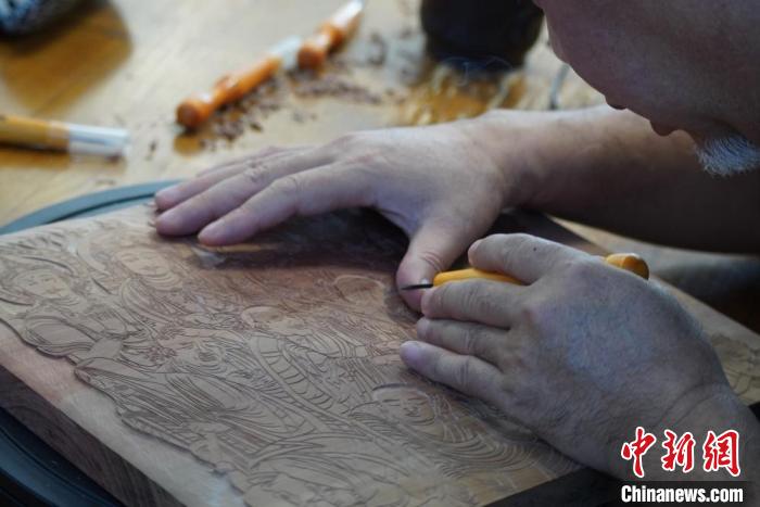 圖為徐晉林湊近木板，近距離制作雕版畫?！【琶赖┰?　攝