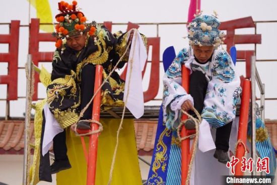 圖為“苦水高高蹺”表演者通過(guò)麻繩將腳固定在腳踏板，并在腿部纏繞六七圈?！【琶赖┰?攝