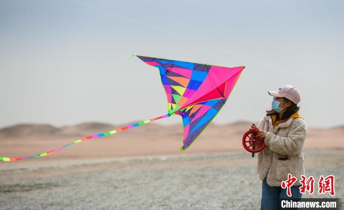 圖為市民正在陽關(guān)景區(qū)放風(fēng)箏。　王斌銀 攝