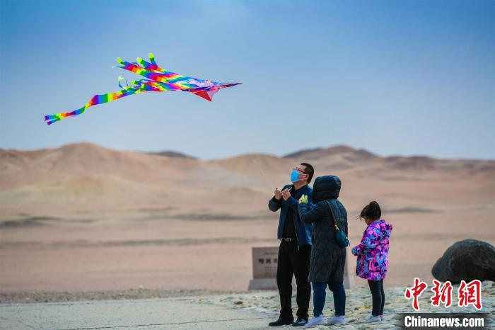 圖為市民正在陽關(guān)景區(qū)放風(fēng)箏。　王斌銀 攝