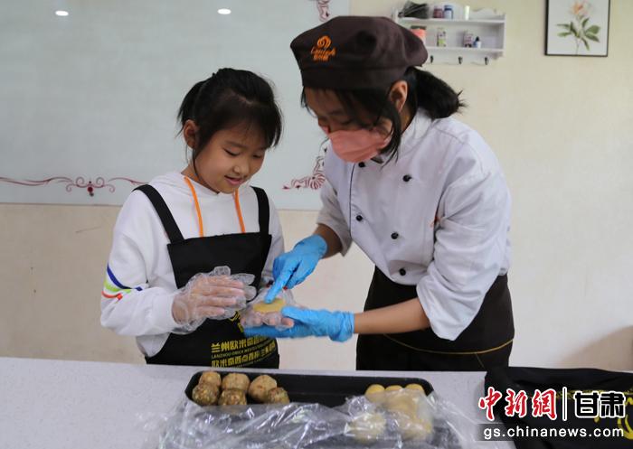 圖為在甘臺胞小朋友在工作人員指導下制作月餅。九美旦增 攝