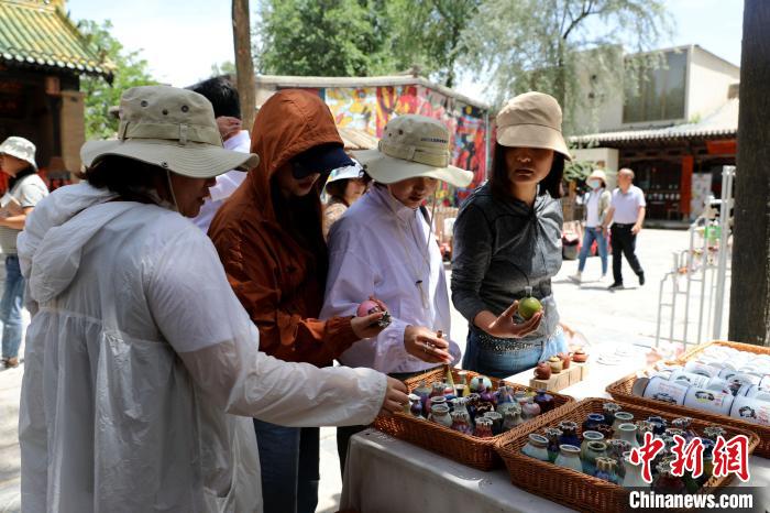 圖為民眾挑選手工藝產(chǎn)品?！⊙Φ?攝