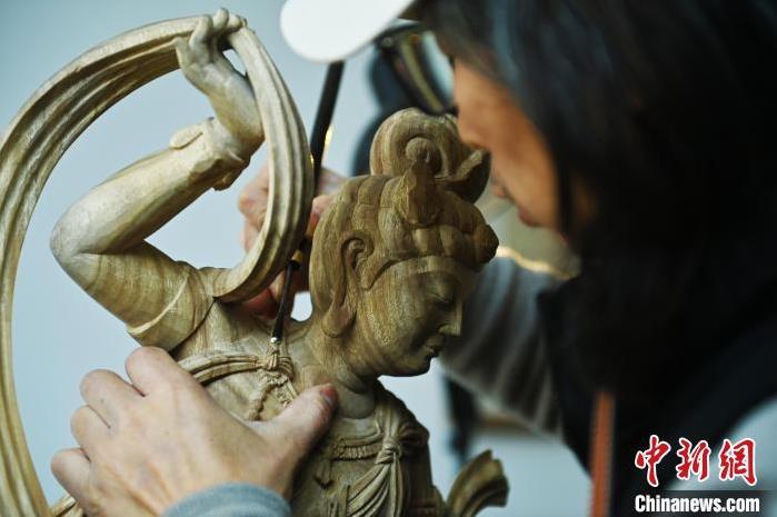 圖為季茂杰進(jìn)行敦煌元素的木雕創(chuàng)作。李亞龍 攝</p>
<p>