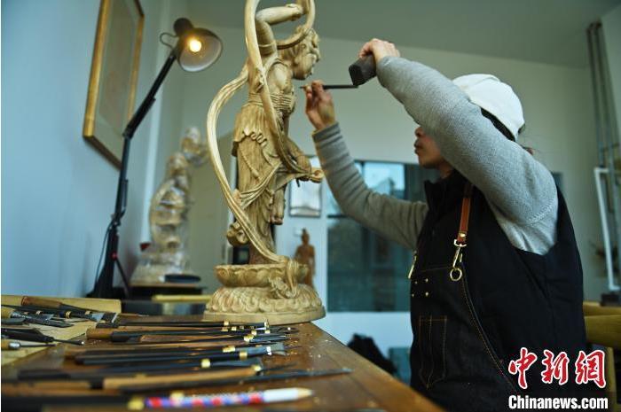 圖為季茂杰進(jìn)行敦煌元素的木雕創(chuàng)作。李亞龍 攝</p>
<p>