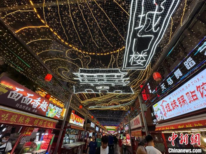 圖為明清街夜市燈光點(diǎn)亮具有武威文化元素的“涼州古城門”彩燈?！〈魑牟?攝</p><p>