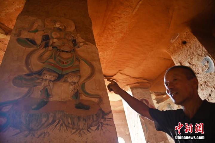 7月15日，甘肅省平?jīng)鍪袥艽h百里石窟長廊羅漢洞石窟內(nèi)，該窟文保員郭建平介紹窟內(nèi)石刻彩繪壁畫。郭建平家中三代人曾自發(fā)保護(hù)羅漢洞石窟。羅漢洞石窟遺存40余個窟龕，以北魏至清代風(fēng)格為主。中新社記者 李亞龍 攝</p>
<p>
