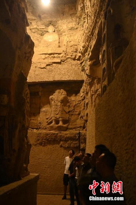 7月15日，游人參觀甘肅省平?jīng)鍪袥艽h百里石窟長廊中的王母宮石窟。百里石窟長廊位于涇川縣境內(nèi)，由512個石窟、5眼窟中石井組成，現(xiàn)存王母宮石窟、鳳凰山石窟、南石窟寺、丈八寺石窟、羅漢洞石窟、太山寺石窟等規(guī)模較大的石窟群，還有數(shù)量眾多的小石窟群。王母宮石窟又名千佛洞，該窟設(shè)計宏大，造像生動，窟內(nèi)擁有造像數(shù)百尊，是較為珍貴的佛教文化遺存。中新社記者 李亞龍 攝</p>
<p>