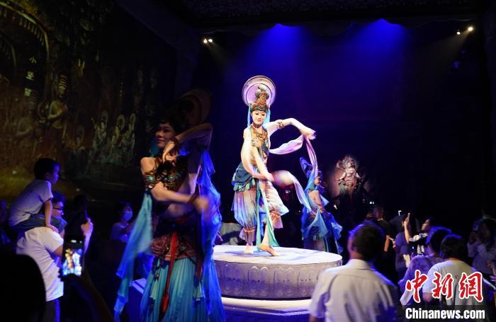 《樂動敦煌》是全球首部洞窟式沉浸體驗劇，利用真人與數(shù)字影像虛實交換實現(xiàn)沉浸式體驗。圖為2023年8月28日晚，《樂動敦煌》演出。(資料圖)中新社記者 毛建軍 攝