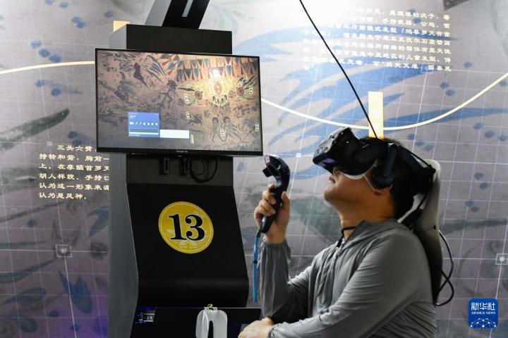 7月22日，游客借助VR設(shè)備沉浸式游覽莫高窟第285窟虛擬場(chǎng)景。新華社記者 郎兵兵 攝